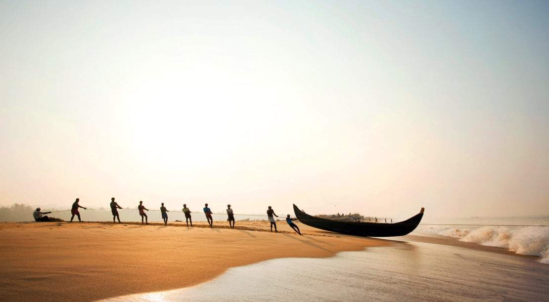 Fishermen bring their boat back to shore at Poovar Beach, near Trivandrum.